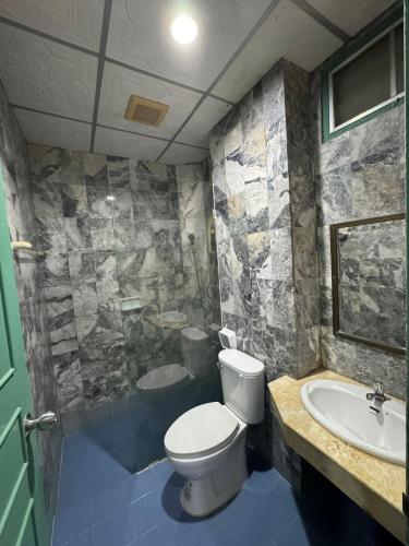 a bathroom with a toilet and a sink at Luxury Hotel ลักเซอรี่ โฮเทล in Ban Don Rak