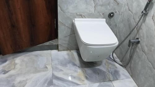 a bathroom with a white toilet in a stone wall at Taj wonder inn in Tājganj