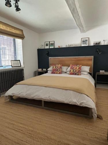 a bedroom with a large bed with a wooden headboard at The Hat Works in Ludlow