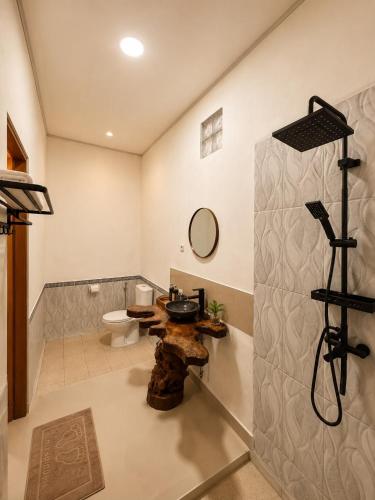 a bathroom with a toilet and a sink at Tegal Luwih Cabin in Munduk
