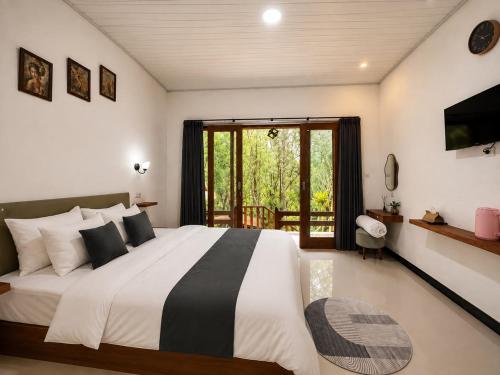 a bedroom with a large bed and a window at Tegal Luwih Cabin in Munduk