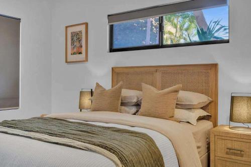 a bedroom with a bed with pillows and a window at Jila Cable Beach in Cable Beach