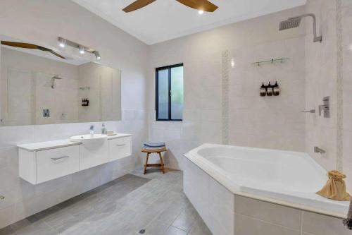 a white bathroom with a tub and a sink at Jila Cable Beach in Cable Beach