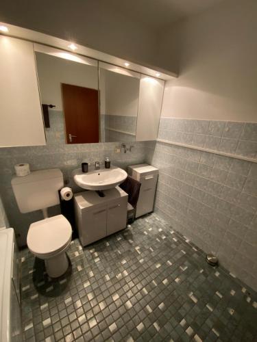 a bathroom with a toilet and a sink and a mirror at Kornblick in Korntal-Münchingen