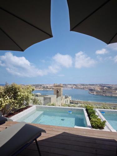a swimming pool with a view of the water at Ursulino Valletta in Valletta