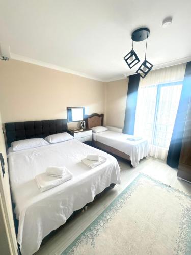 a bedroom with two beds and a window at Mira Residence in Bostancı