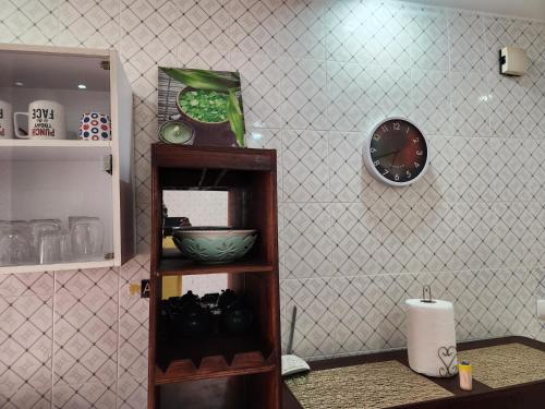 a room with a shelf with a clock on a wall at Américain studio ngor almadies in Dakar