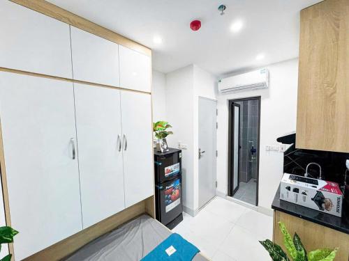 a kitchen with white cabinets and a stove at Khach san Ngoc Ha in Ninh Binh