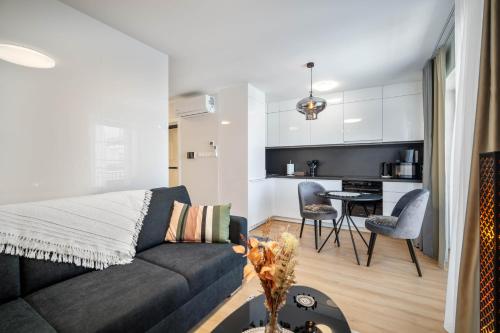 a living room with a couch and a kitchen at NOVERA Apartments - #C in Turčianske Teplice