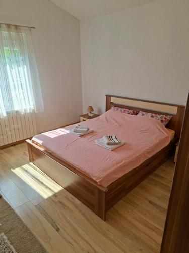 a bedroom with a bed with pink sheets and a window at Village house Tea in Virpazar