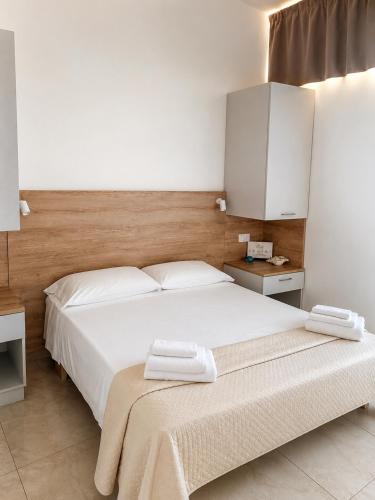 a bedroom with a large white bed and a cabinet at Acrita Superior in Mandaradoni