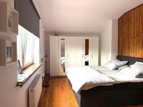 a bedroom with a large bed and a large window at Dom Szalkowo Jeziorak Pavillon in Szałkowo