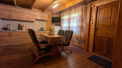 a kitchen with a table and chairs in a room at DAGA-Domki Nad Soliną in Solina