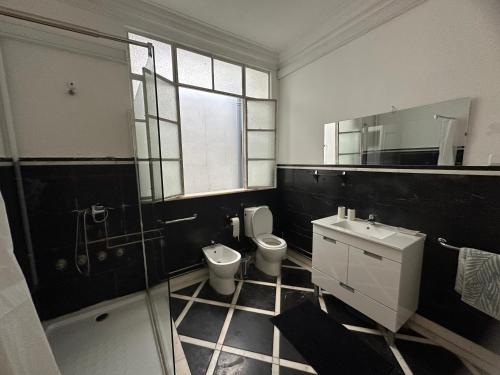 a bathroom with a toilet and a sink and a mirror at ICOSIUM Hostel in Braga
