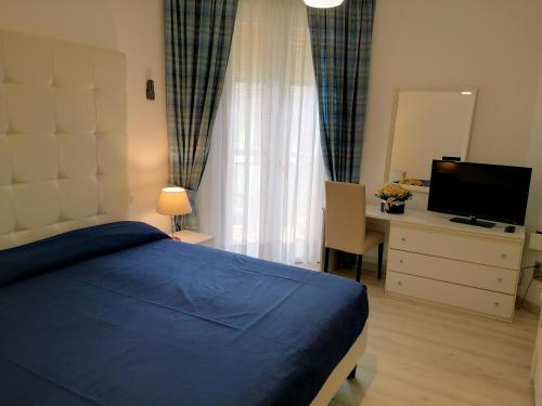 a bedroom with a bed and a desk and a television at Hotel King in Lido di Jesolo