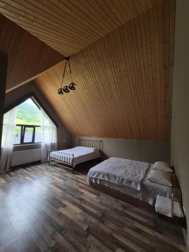 a bedroom with two beds and a wooden ceiling at Villa Okatse in Zeda-Gordi