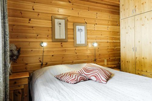 a bedroom with a bed in a wooden wall at Orrenkolo, Lapland in Luosto