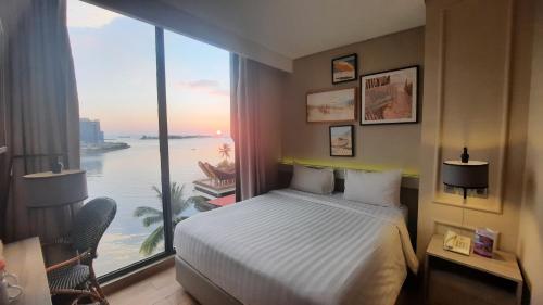 a hotel room with a bed and a large window at Expressia Hotel Makassar in Makassar