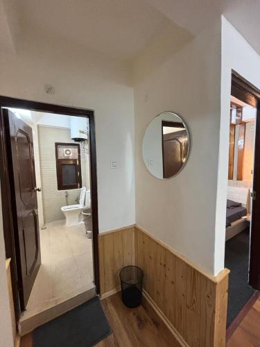 a room with a bathroom with a mirror and a sink at Hotel Nivasa, Narkanda in Nārkanda