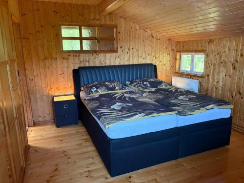 a bedroom with a bed in a wooden cabin at Chata Na Mechu in Dolní Podluží