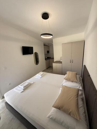 a large white bed in a room with at Apartmani Lovren in Novalja