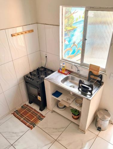 a small kitchen with a stove and a sink at Residência Ilha Bela - Casa Inteira no Centro Histórico de São Luís in São Luís