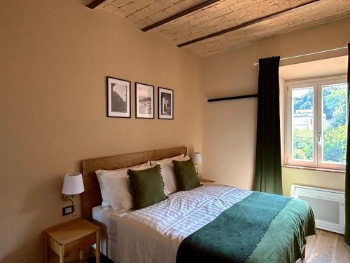 a bedroom with a bed and a window at Edera Rooms in Tolfa