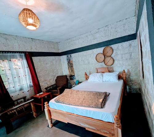 a bedroom with a bed and a chair in it at Alkebulan cottages in Uru
