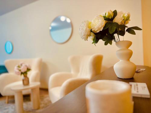a vase with flowers on a table in a room at Central Apartment in Kyustendil