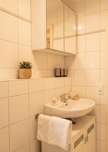 a white bathroom with a sink and a mirror at GLORYSTAY - Business Studio-Bosch Campus 2km-Tiefgarage-Workspace-Renningen in Renningen