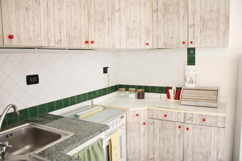 a kitchen with wooden cabinets and a sink at Appartamento Mura in Forio d'Ischia