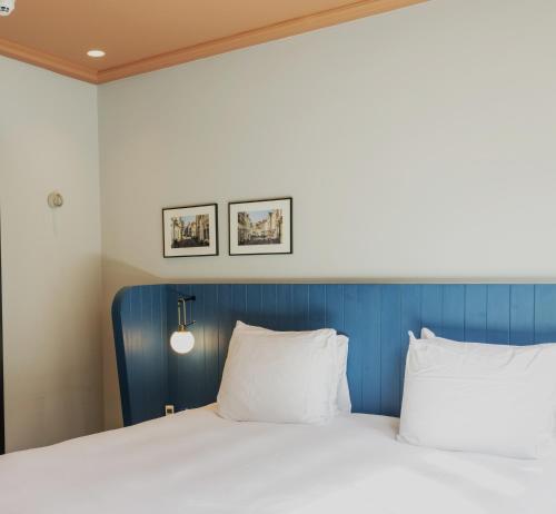 a bed with a blue headboard and two pillows at Cozy Pillow in Utrecht
