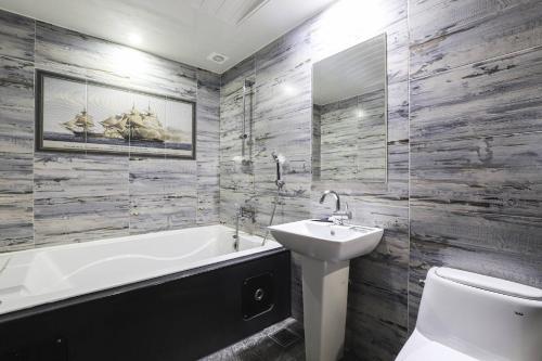 a bathroom with a tub and a sink and a toilet at 세븐호텔 in Daegu