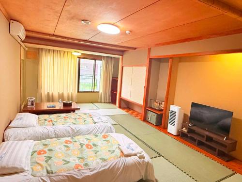 a hotel room with two beds and a flat screen tv at RB hotel in Aizuwakamatsu