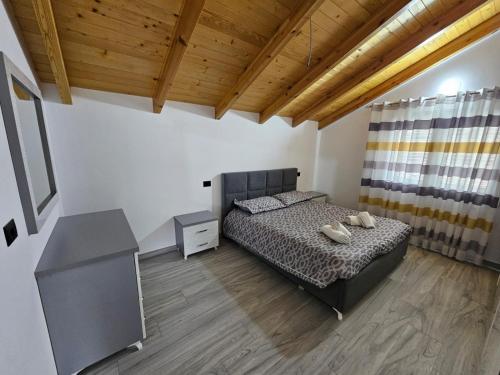 a bedroom with a bed and a wooden ceiling at Vila Elbasan in Labinot i Poshtëm