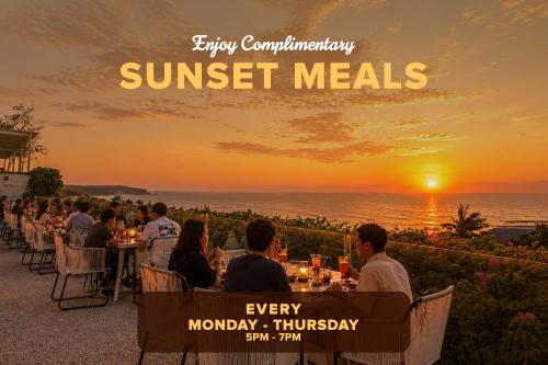 a group of people sitting at tables watching the sunset at Klapa Resort in Uluwatu