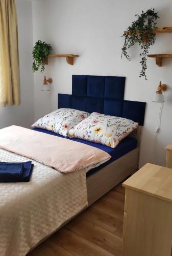 a bed with a blue headboard in a room at Apartament nad Soliną in Polańczyk
