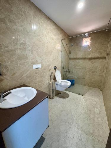 a bathroom with a sink and a toilet and a shower at Kamaksha Palace in Sundarnagar