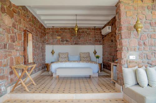 a bedroom with a bed in a brick wall at Diar illi in Touama