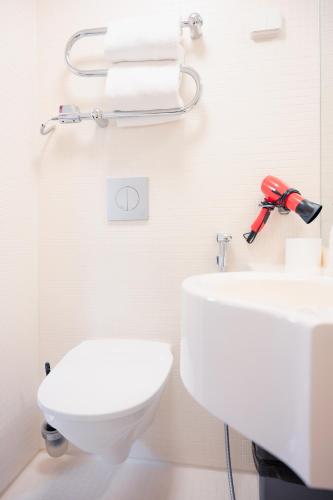 a bathroom with a white toilet and a sink at Omena Hotel Helsinki City Centre in Helsinki