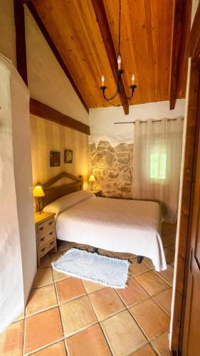 a bedroom with a bed and a wooden ceiling at Lugar dos Devas in Covelo
