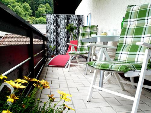 d'une terrasse avec des chaises vertes et blanches et une table. dans l'établissement Hofwiese, à Hohenschwangau