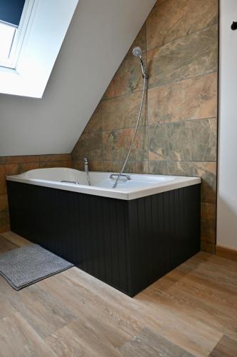 a bathroom with a bath tub in a attic at Superbe Loft proche Troyes & Parking facile in Arcis-sur-Aube