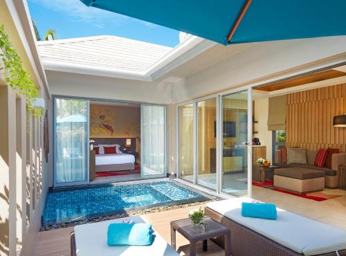 a villa with a swimming pool and a patio at Grand Mercure Phuket Patong in Patong Beach