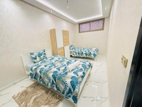 a bedroom with a bed with blue and white sheets at Manifique renovated apartment Marrakech in Marrakesh
