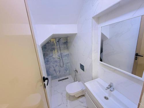 a white bathroom with a toilet and a sink at Manifique renovated apartment Marrakech in Marrakesh