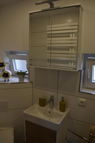 ein Badezimmer mit einem weißen Waschbecken und einem Fenster in der Unterkunft Ferienwohnung Wesernest in Hessisch Oldendorf
