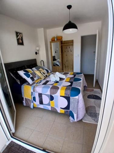 a bedroom with a bed with a colorful comforter at L'Escale Orléans Chambres d'hôtes in Orléans