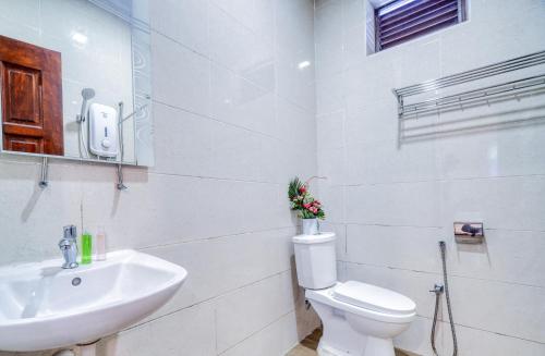 a white bathroom with a toilet and a sink at Rivora Gopeng in Gopeng