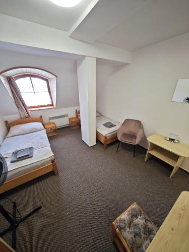 a large room with two beds and a window at Penzion Moyzes in Banská Bystrica
